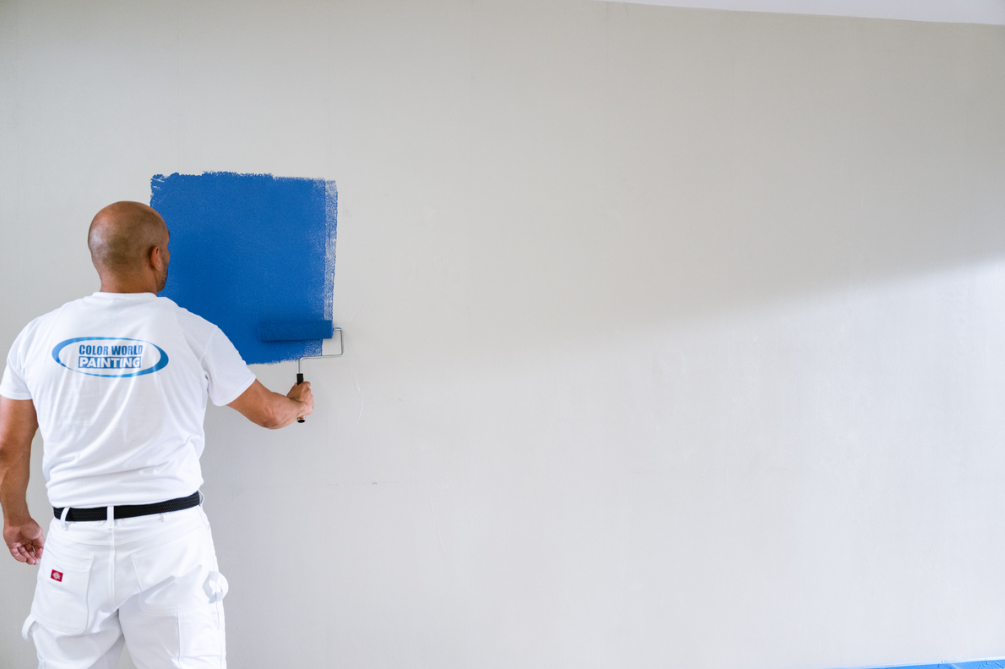 man painting wall blue